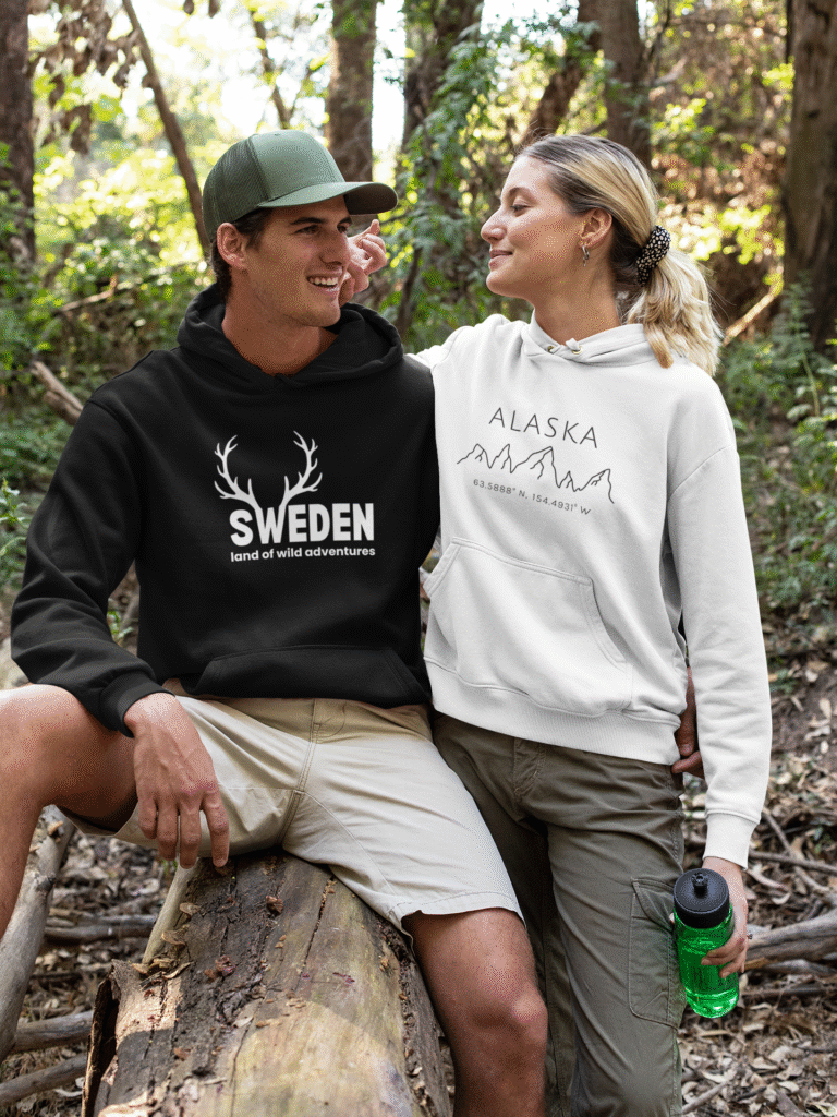 a man and woman in the forest wearing black and white hoodies